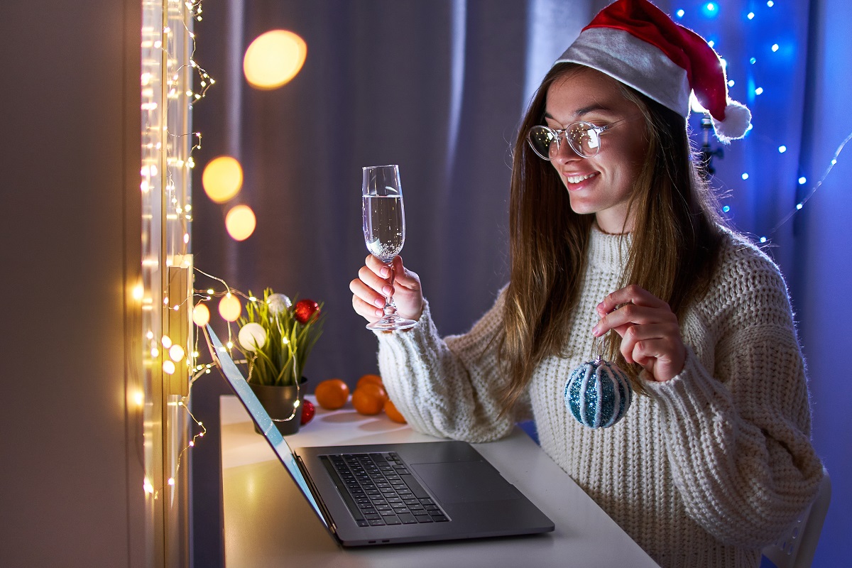 Young happy fun joyful woman wearing santa hat drinking champagn