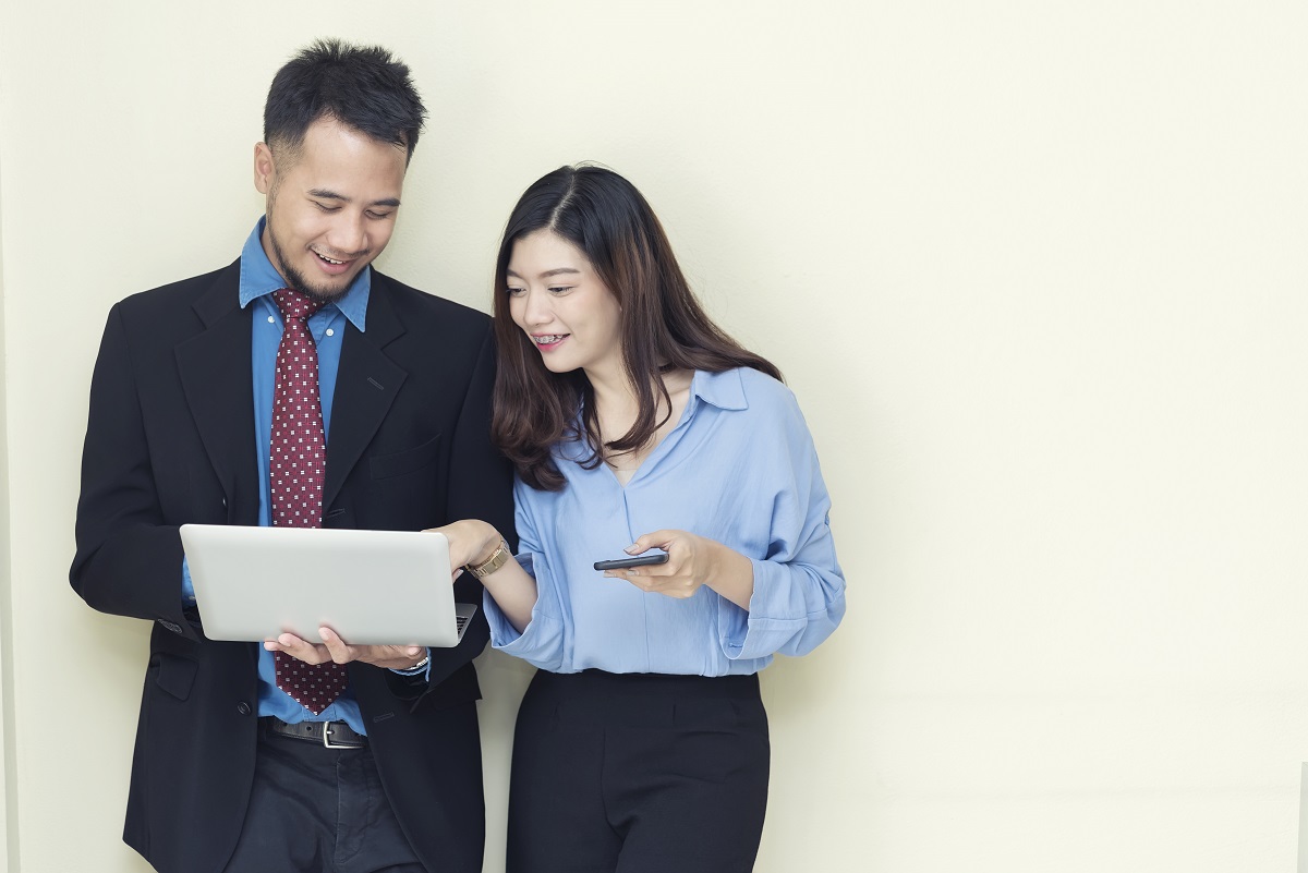 Two Business People Working And Talking About Job With Mobile An